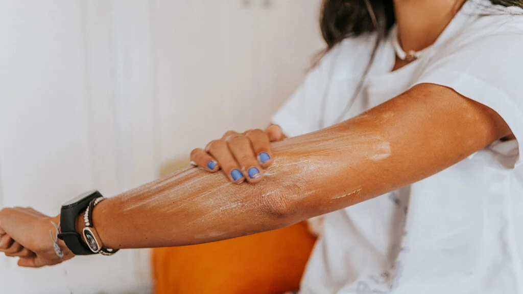 Diagram showing how sunscreen spreads, glides, and forms a uniform protective film across the skin surface